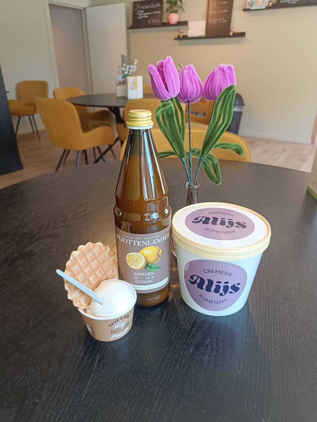 Een pot Alijs-ijs om mee te nemen, naast een bekertje
