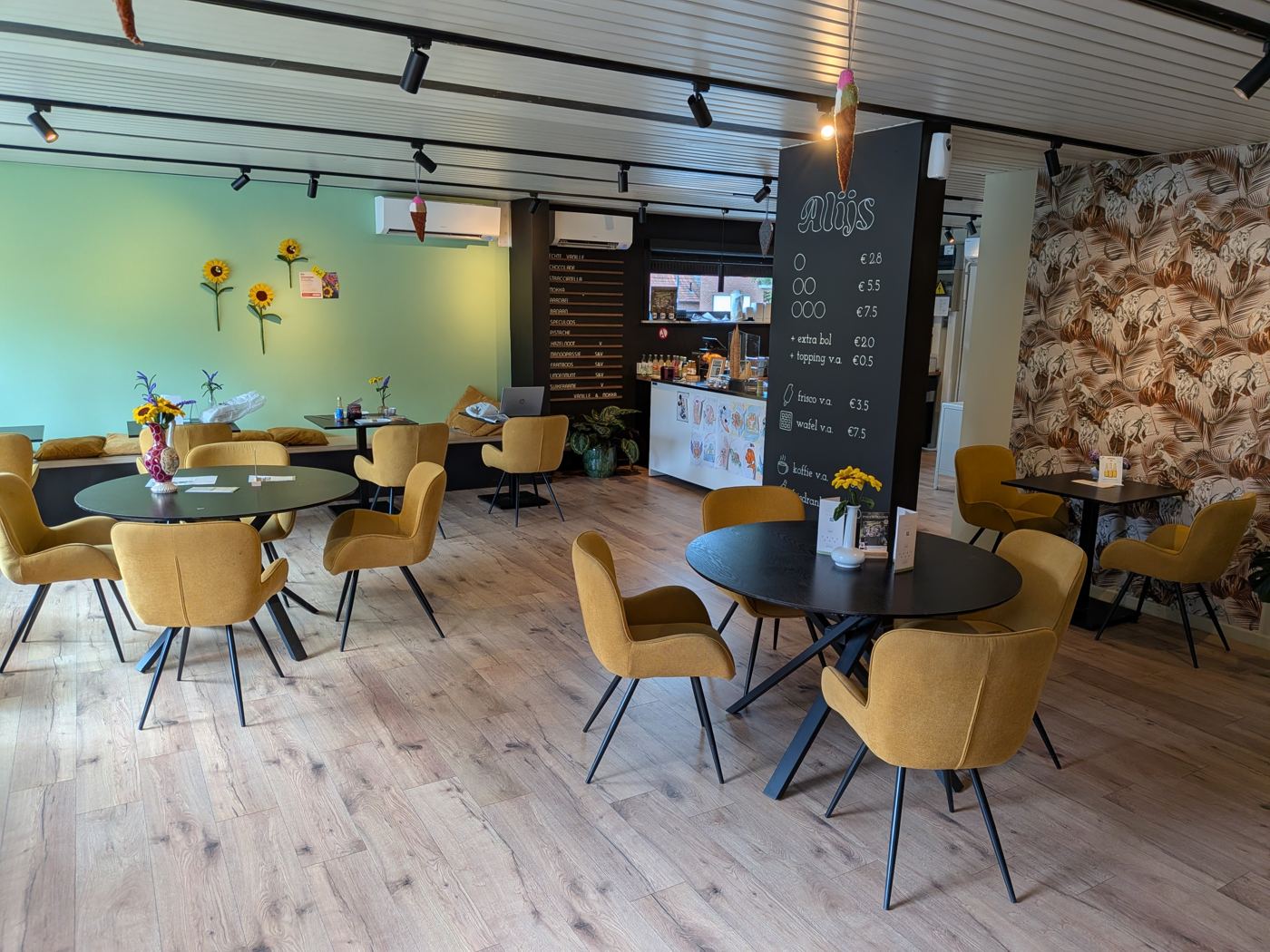 De zitruimte van Cremerie Alijs met gele stoelen