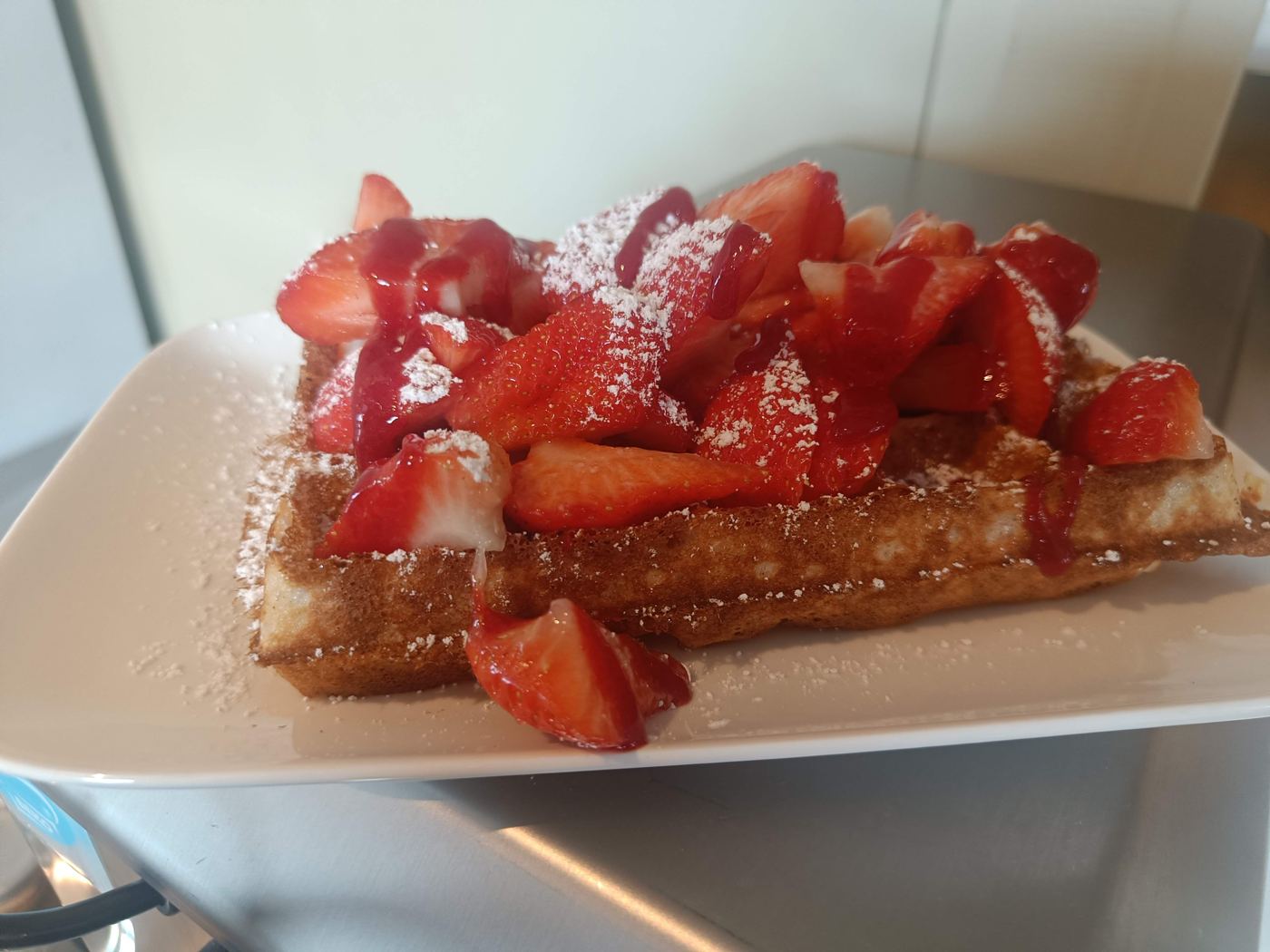 Een Brusselse wafel met verse aardbeien en poedersuiker